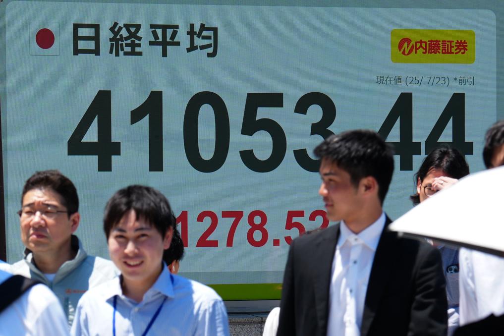 7月23日,行人经过位于日本东京的电子股指显示屏。新华社记者贾浩成摄