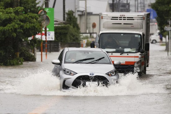 这是2023年7月10日在日本福冈县久留米市拍摄的在积水中行驶的汽车。新华社/共同社