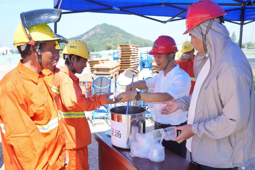 7月3日，在浙江省绍兴市上虞区长塘镇，104国道改建工程上虞段的建筑工人在工地领绿豆汤解暑。（新华社记者 翁忻旸 摄）