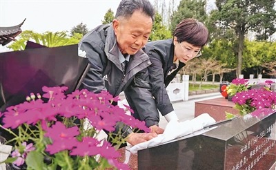 王太平父女擦拭杜治贤墓碑。顾建春摄