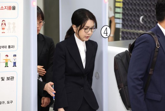 这是8月12日在韩国首尔中央地方法院拍摄的韩国前总统尹锡悦妻子金建希（中）。新华社/纽西斯通讯社