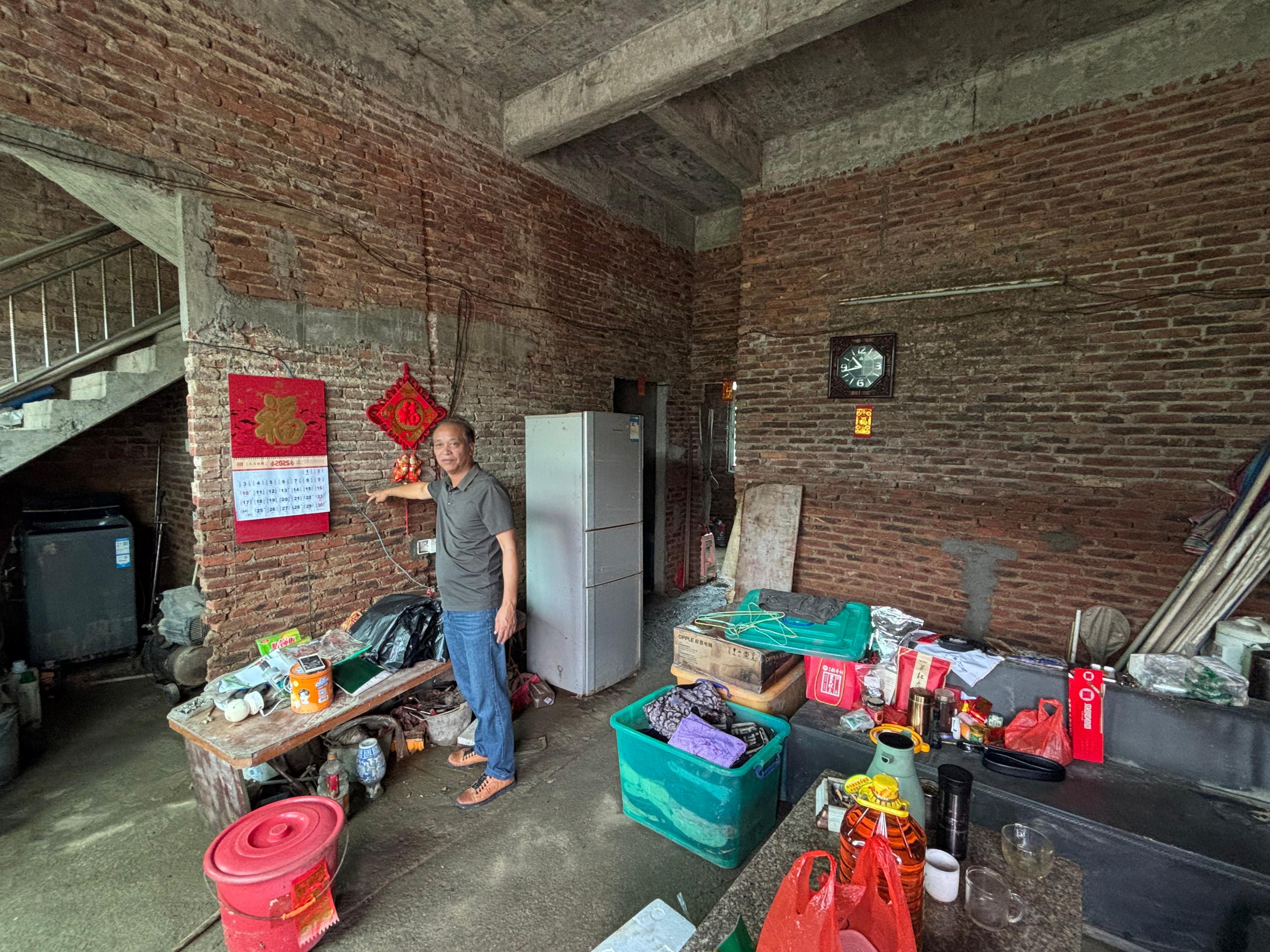达溪村村干部指认房屋淹没洪痕。受访者供图