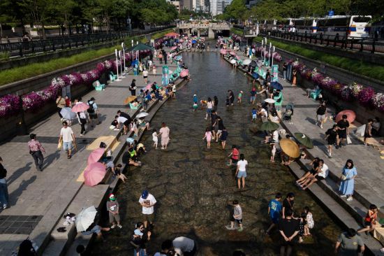 6月14日,人们在韩国首尔的清溪川戏水。新华社发(全休相摄)