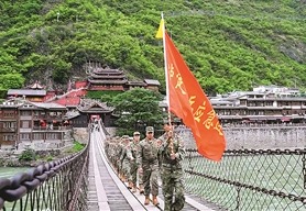 近日,四川省泸定县人武部组织民兵重走长征路。图为队伍行进在泸定桥上。张 政摄