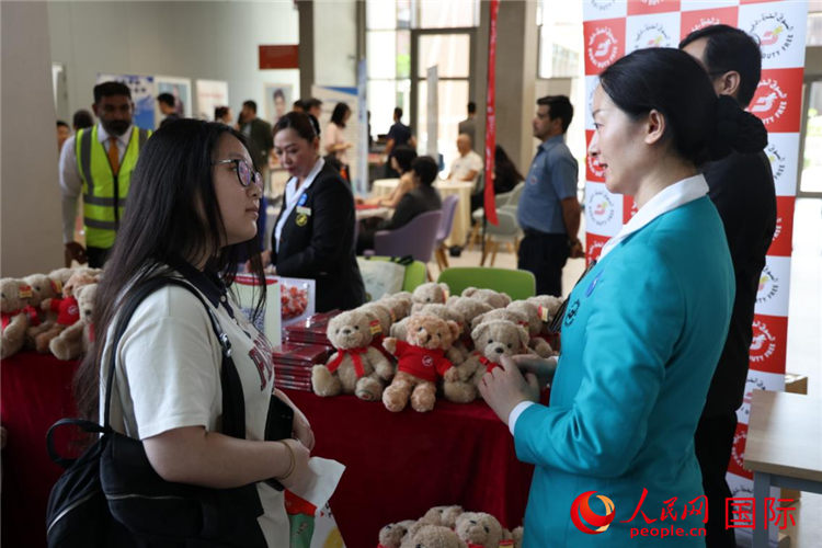 招聘会上,求职者在一家当地企业展台咨询。人民网记者 张志文摄