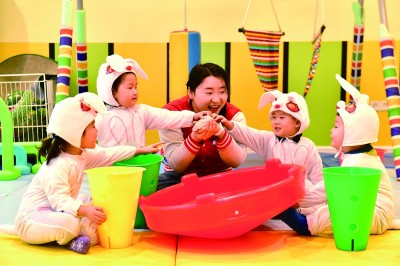 在山东省日照市东港区一家托幼园，老师陪伴孩子做游戏。新华社发