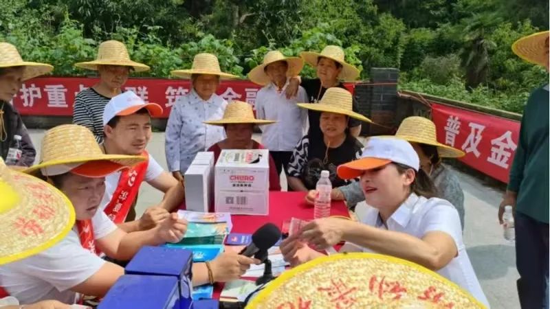 武汉分行驻村干部向村民普及假币识别知识。