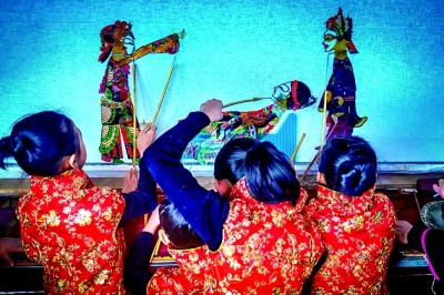 孩子们在尝试表演复州皮影戏。
