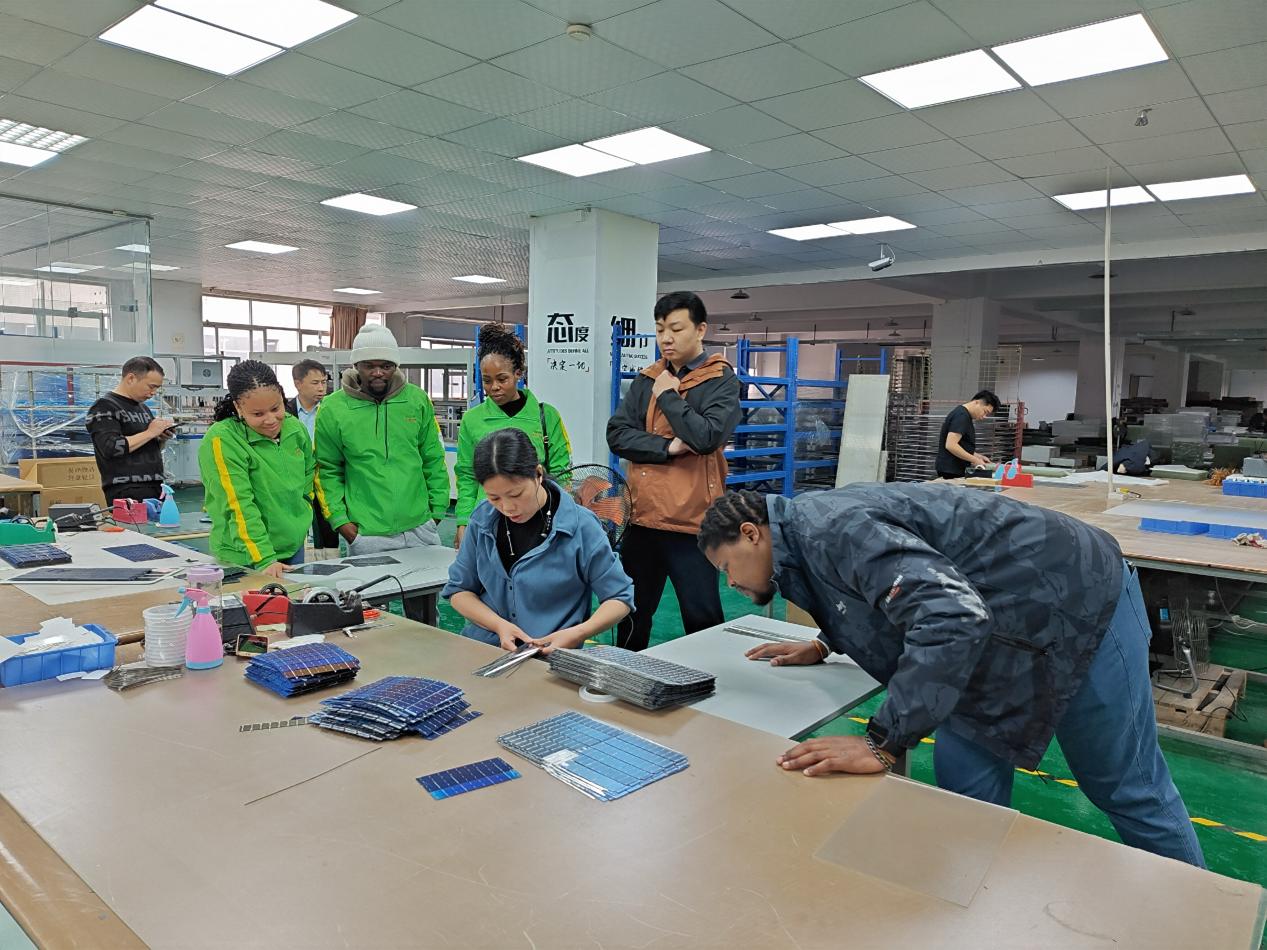 南非留学生学习光伏电池并联焊接工艺。学校供图