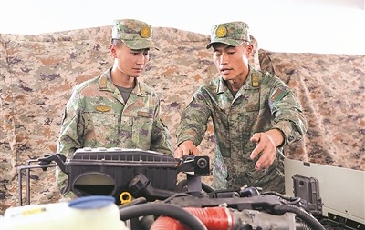 雷耀明(右)给战友讲解装备操作要点。马新周 摄
