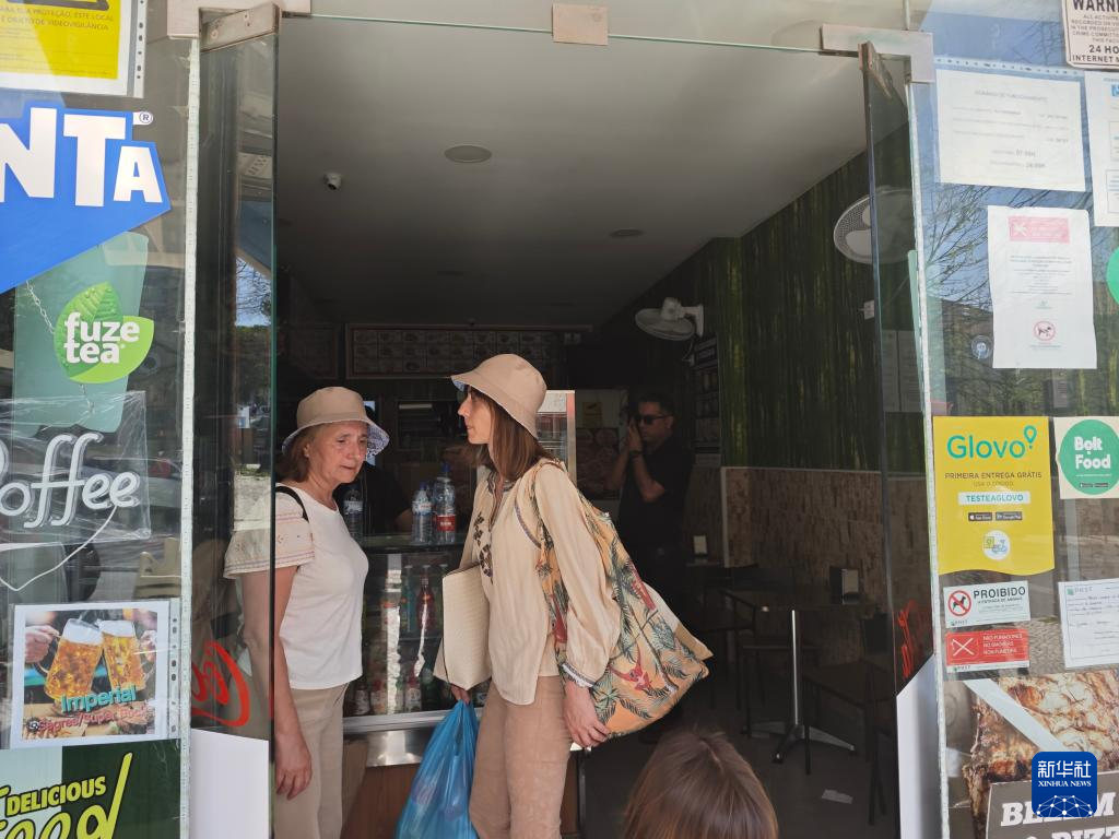 4月28日，在葡萄牙里斯本，顾客在一家停电的小吃店等候（手机照片）。新华社记者 荀伟 摄